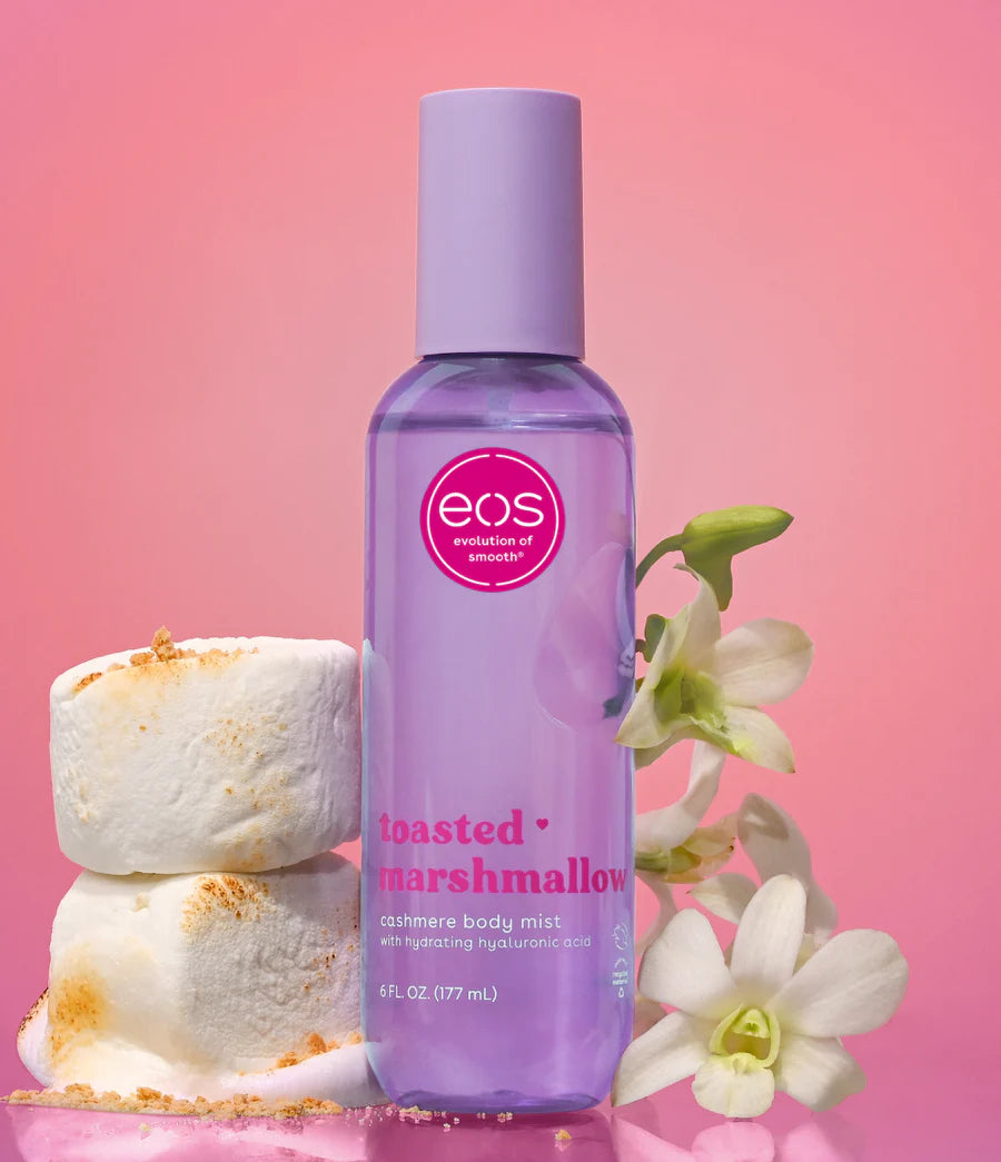 EOS Toasted Marshmallow body mist bottle with marshmallows and flowers on a pink background. Purchase from www.americanbodycare.co.uk