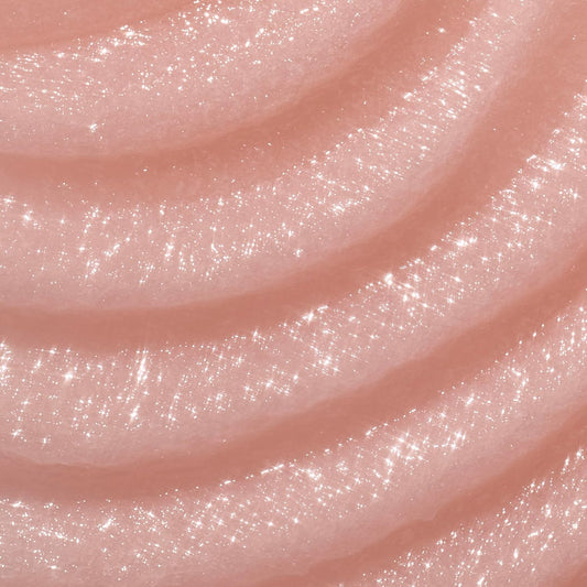 Close-up of pink glittery slime with a glossy finish. A jar of Tree Hut Moroccan Rose Shea Sugar Scrub with a peach-pink body and a metallic copper lid, shown on a white background with a brown 'America's #1 Body Scrub Brand' . purchase from www.americanbodycare.co.uk