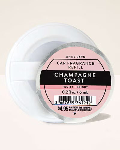 Car fragrance refill labeled 'Champagne Toast' by White Barn on a beige background. Purchase from www.americanbodycare.co.uk 
