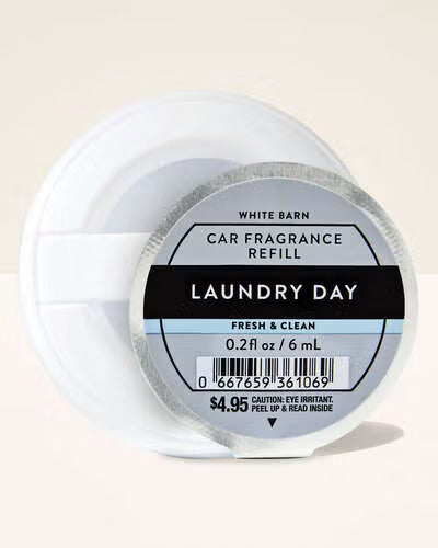 White Barn Car Fragrance Refill labeled 'Laundry Day' on a light pink . Purchase from www.americanbodycare.co.uk background