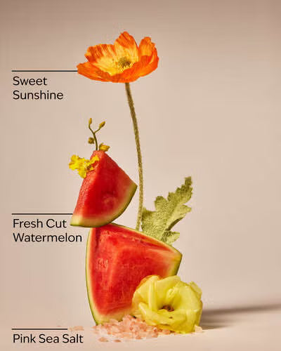 Decorative arrangement with watermelon, flowers, and pink sea salt on a beige background. Purchase from www.americanbodycare.co.uk 