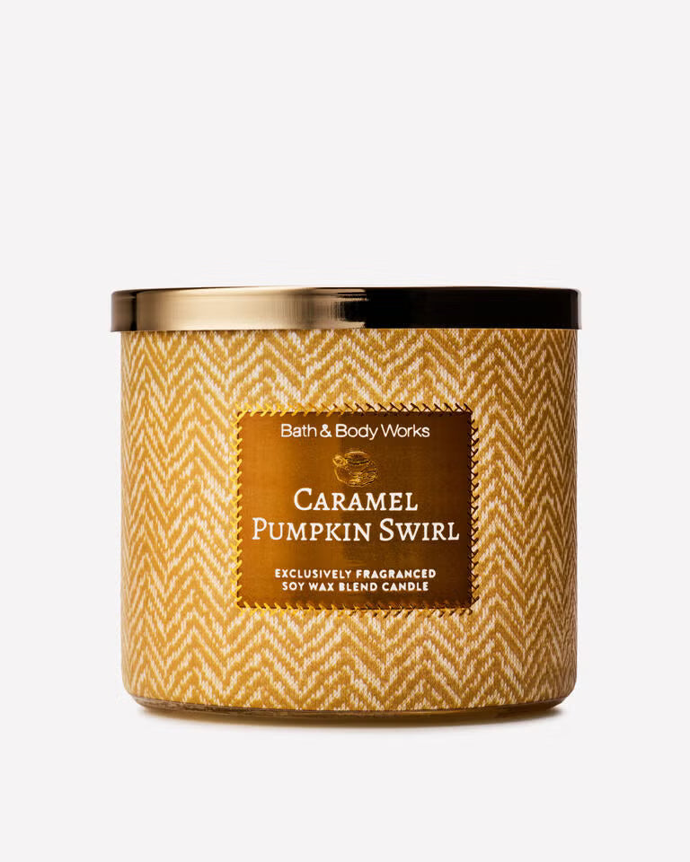 Bath & Body Works Caramel Pumpkin Swirl soy wax candle in a clear glass jar with a gold and white herringbone pattern, a gold label, and a gold lid, on a light gray background. Purchase from www.americanbodycare.co.uk 