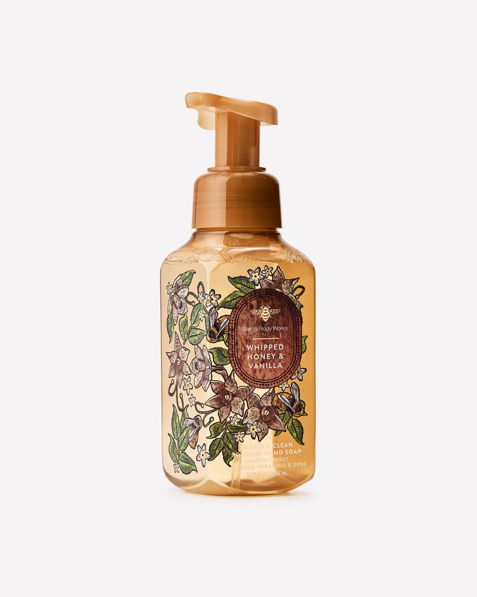 A bottle of Whipped Honey and Vanilla hand soap by The Soap Company, featuring a frosted amber bottle with a brown pump dispenser and an illustrated label of honey bees and flowers. Purchase from www.americanbodycare.co.uk 
