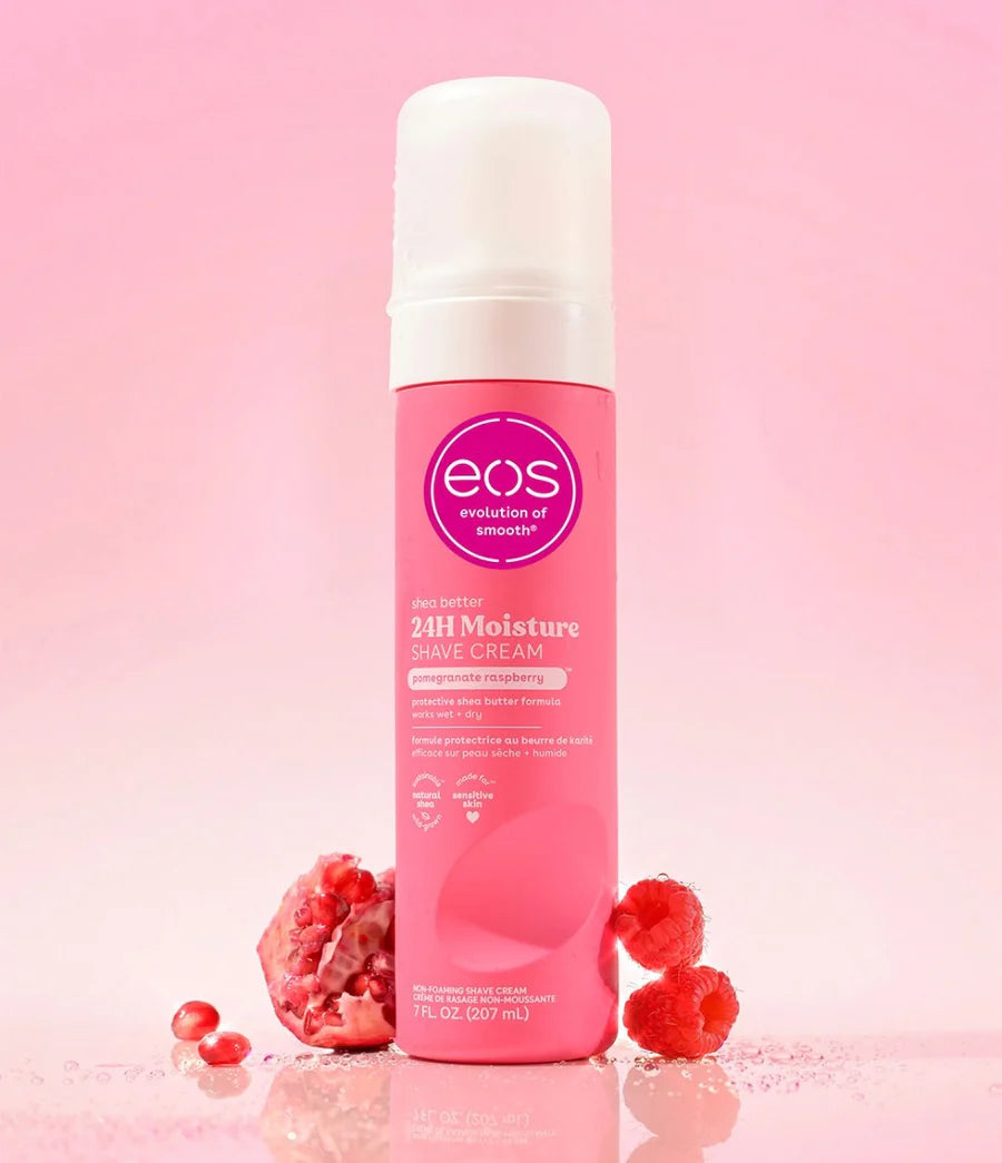 Pink bottle of eos 24H Moisture Shave Cream on a pink background with raspberries. purchase from americanbodycare.co.uk