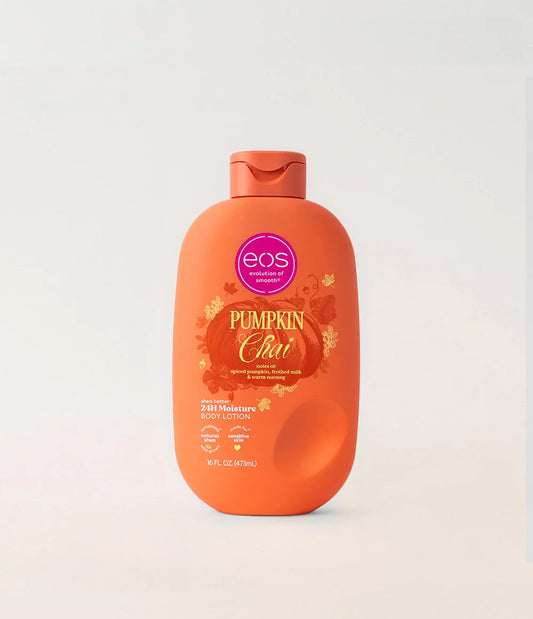 A bottle of EOS Pumpkin Chai body lotion in a bright orange color, featuring a matching orange flip-top cap and a label with autumn-themed graphics, set against a clean off-white background. purchase from www.americanbodycare.co.uk
