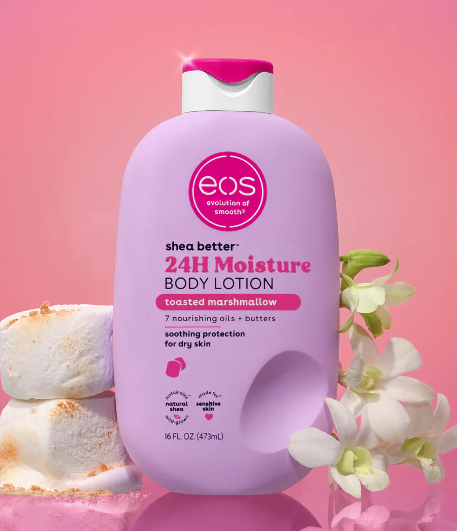 EOS shea butter 24H Moisture body lotion bottle with marshmallows and flowers on a pink background. Purchase from www.americanbodycare.co.uk 