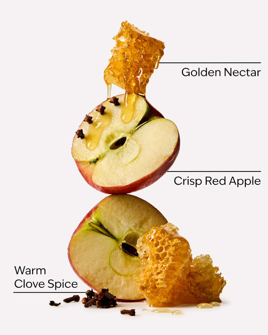 A stylized product graphic showing a sliced red apple with honey dripping from a honeycomb piece, plus clove spice and text labels reading 'Golden Nectar,' 'Crisp Red Apple,' and 'Warm Clove Spice' on a light gray background. A single spool of White Barn Car Fragrance Refill in the scent 'Leaves', shown on a clean white background. purchase from www.americanbodycare.co.uk