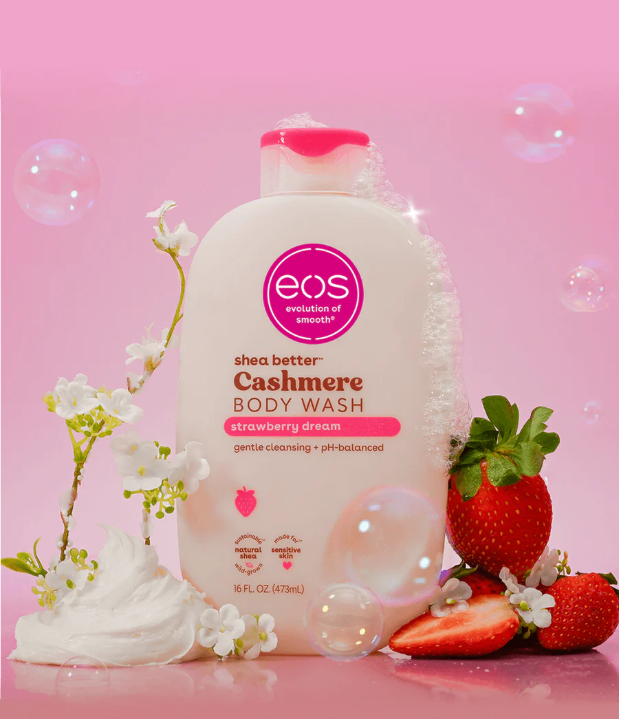 eos shea butter Cashmere Body Wash with strawberries and flowers on a pink background. Purchase from americanbodycare.co.uk 