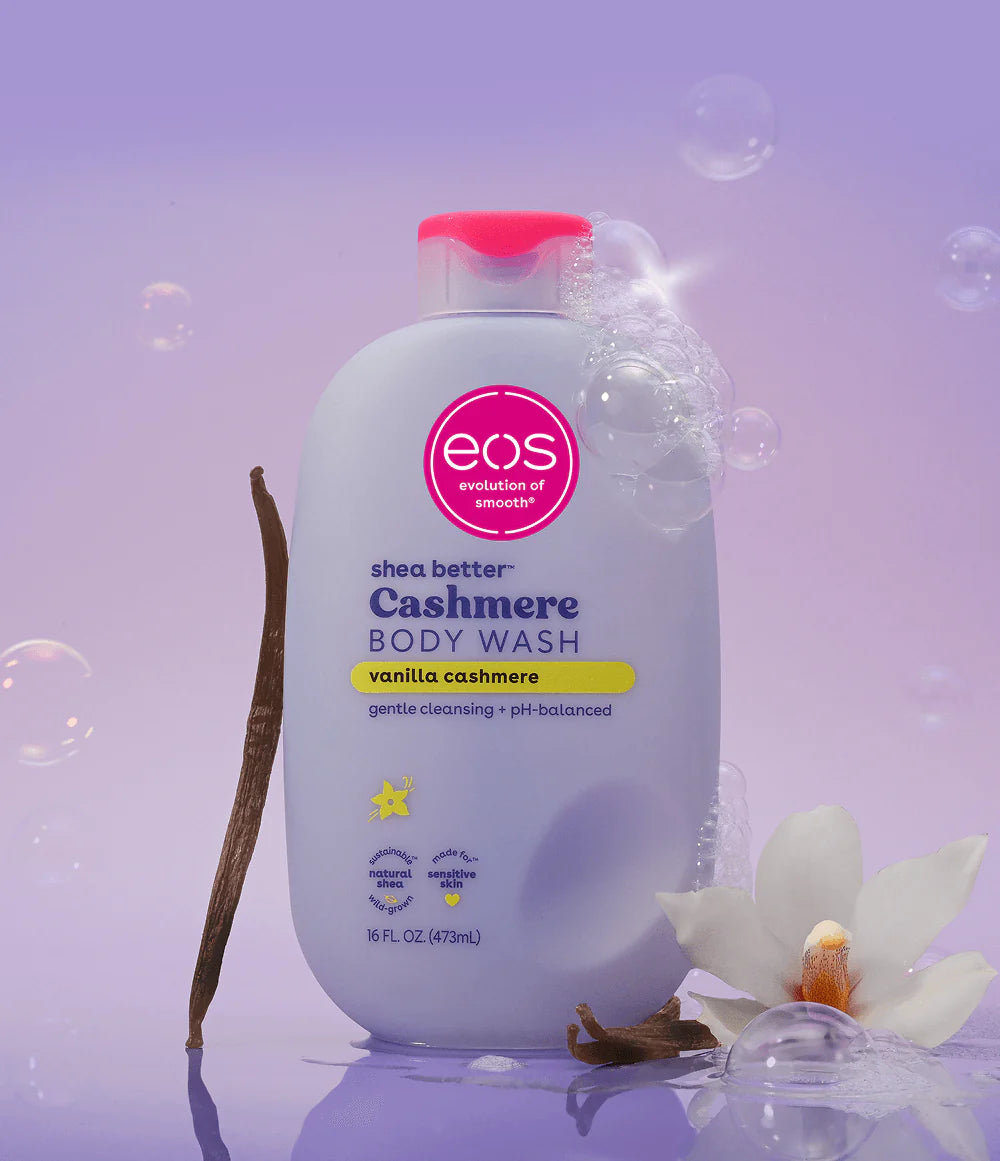 eos shea butter Cashmere Body Wash bottle on a purple background with vanilla bean and flower. Purchase from americanbodycare.co.uk