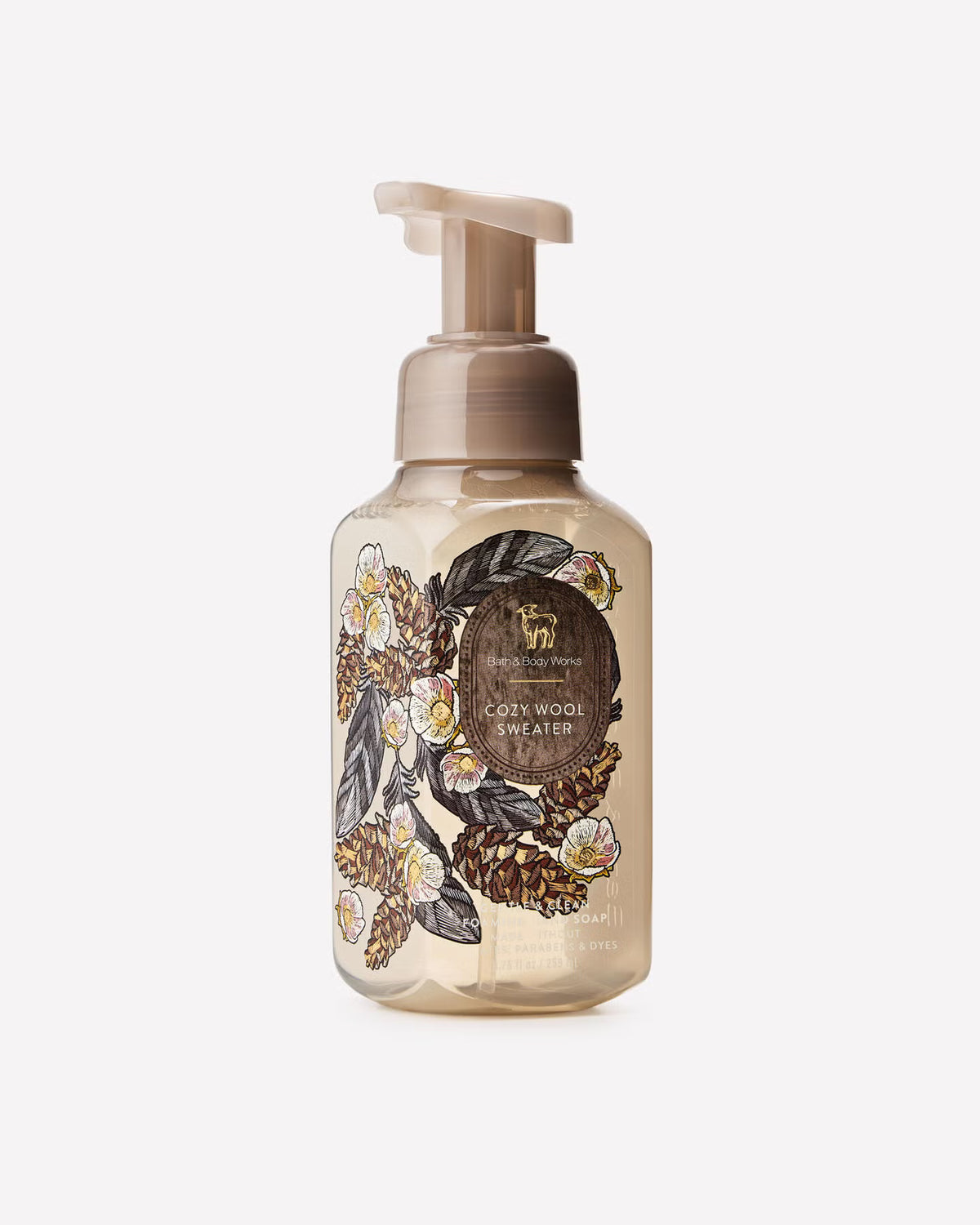 A bottle of L'Envers Cosy Wool Sweater hand wash with a beige pump dispenser. The clear bottle shows a warm beige liquid inside and features an artistic label with pinecones, leaves, and white flowers. Purchase from www.americanbodycare.co.uk
