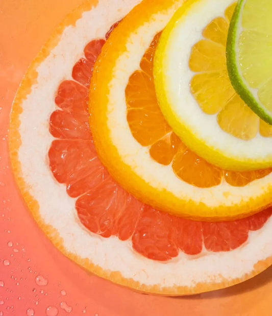 Close-up of sliced citrus fruits on a pink background