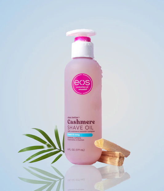 Bottle of eos Cashmere Shave Oil with a pink label on a light blue background. Purchase from americanbodycare.co.uk 