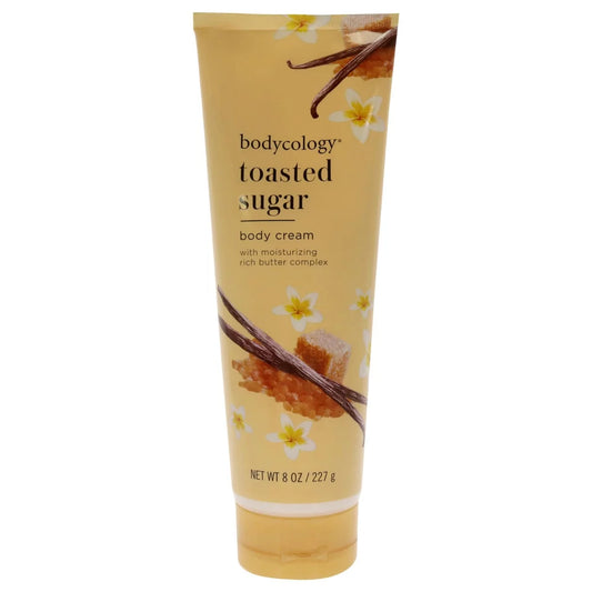 A 6 oz squeeze tube of bodycology Toasted Sugar Body Cream, featuring a warm beige and yellow design with illustrations of vanilla beans, honeycomb, and white flowers. purchase from www.americanbodycare.co.uk